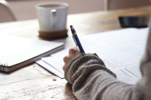 Woman writing on paper with a pen